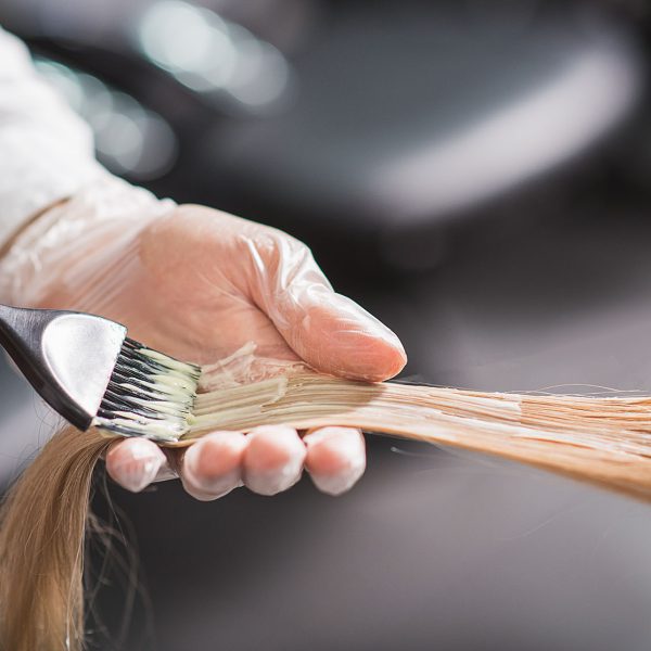 Man in gloves is dying hair